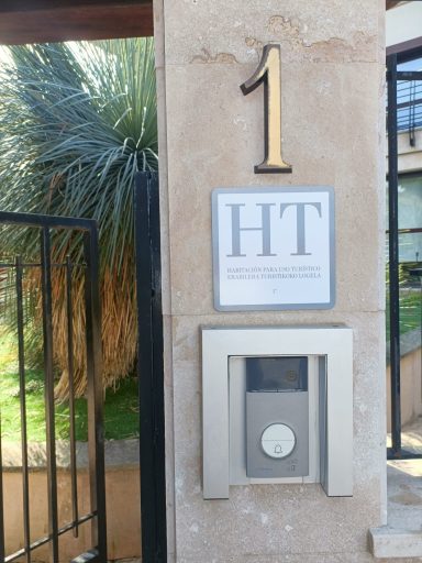 Habitaciones de uso turístico en vivienda particular Número 1 en la fachada con un timbre y letrero "HT" adjunto.